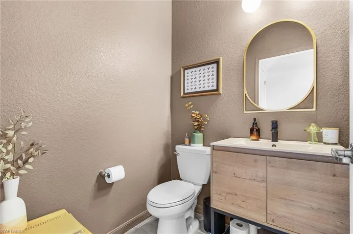 Half bathroom with a textured wall and vanity