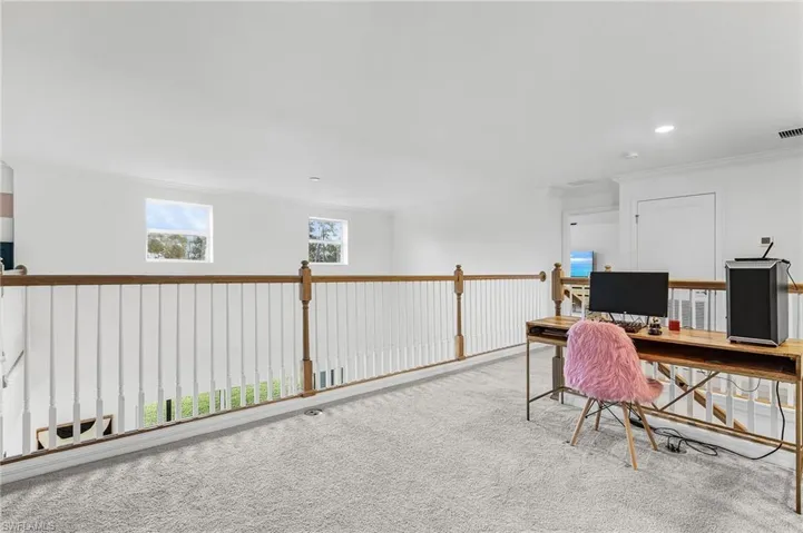 Carpeted office space with ornamental molding and recessed lighting