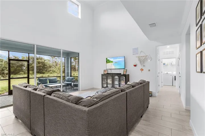 Living room featuring independent washer and dryer and a high ceiling