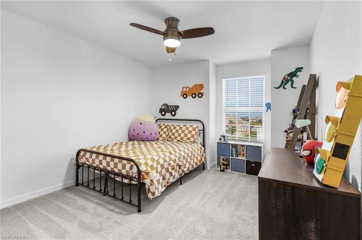 Carpeted bedroom with baseboards and a ceiling fan