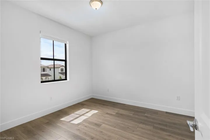 Spare room featuring baseboards and wood finished floors
