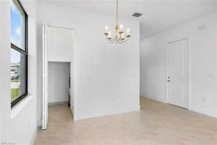 Unfurnished room with hanging lights and light tile patterned floors