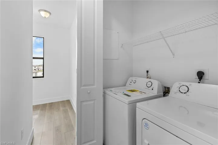 Laundry area with light wood finished floors and washing machine and dryer