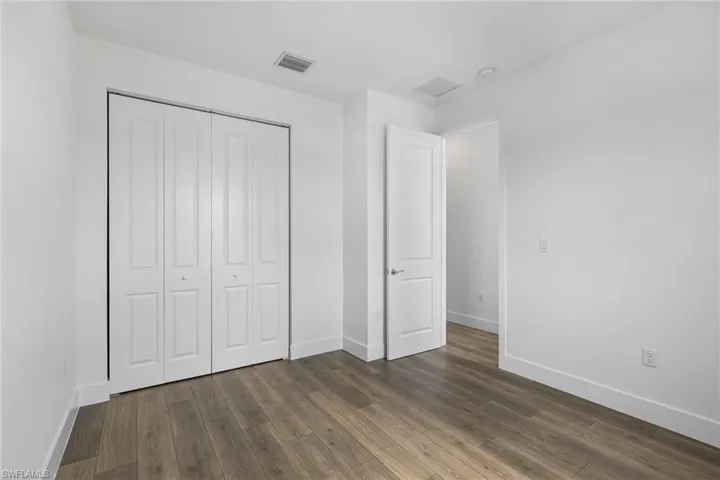Unfurnished bedroom with a closet and dark wood finished floors