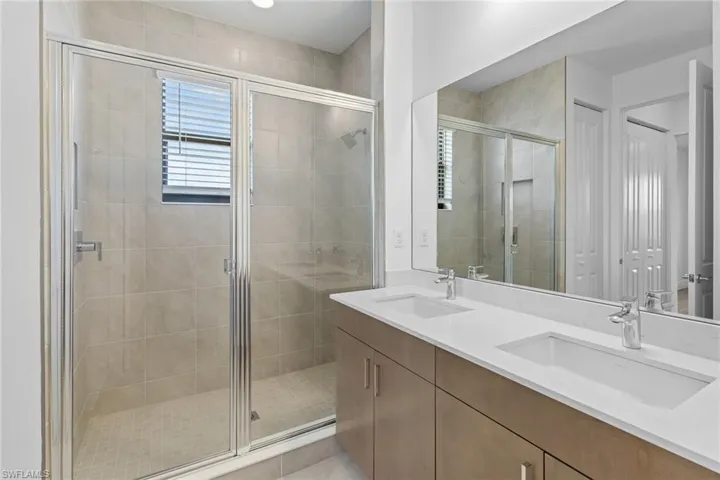 Bathroom with double vanity and a shower stall