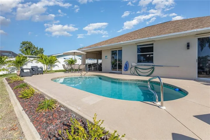 Inviting outdoor space featuring a kidney-shaped swimming pool with a handrail