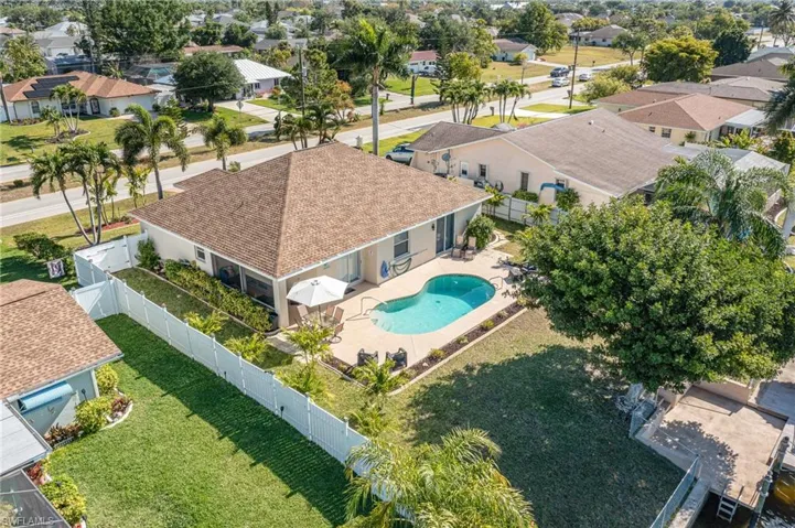 Residential property featuring a hip roof, private swimming pool, and concrete pool deck