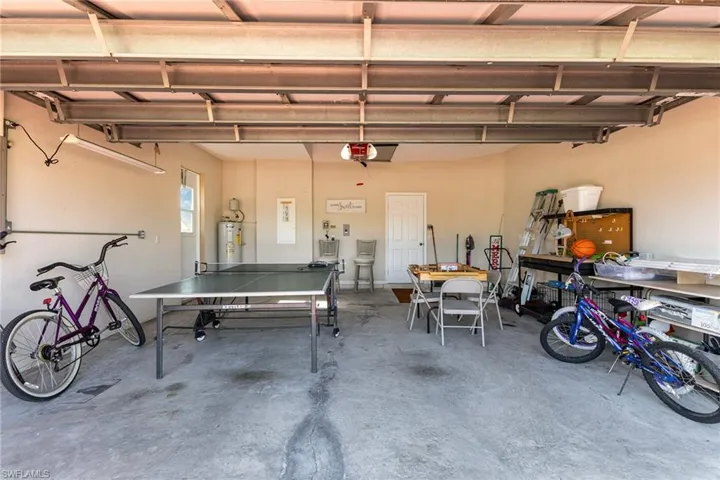 Spacious garage with concrete flooring, painted walls, and an overhead garage door mechanism