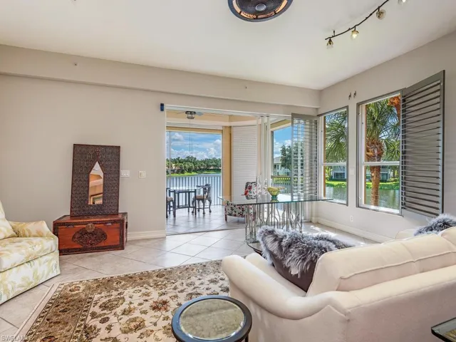 Living room with light tile patterned floors, track lighting, and a wealth of natural light