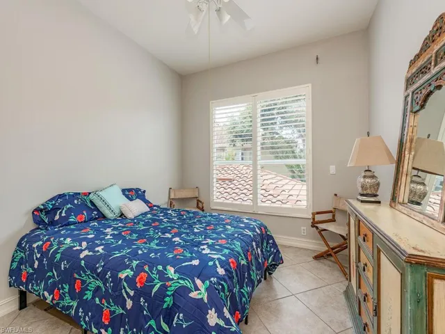 Tiled bedroom featuring ceiling fan