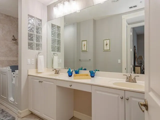 Bathroom featuring tile patterned floors and dual bowl vanity