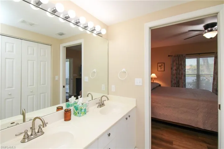 Bathroom with hardwood / wood-style flooring, dual vanity, and ceiling fan