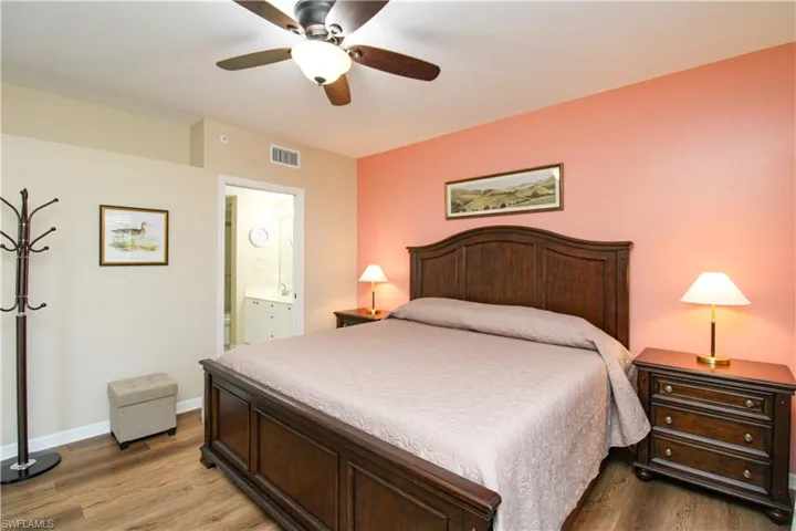 Bedroom featuring wood-type flooring, ensuite bathroom, and ceiling fan
