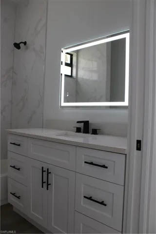 Bathroom featuring vanity and shower / bath combination