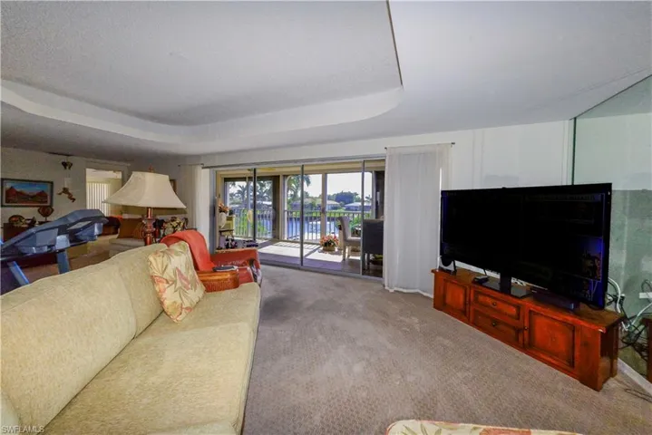 Living room with a raised ceiling and carpet floors