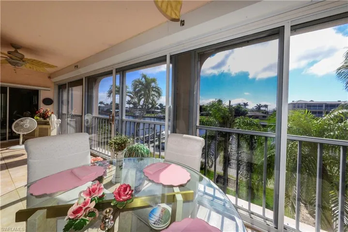 Sunroom featuring a water view and ceiling fan