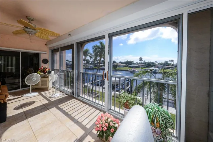 Sunroom / solarium with a water view and ceiling fan