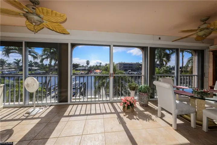 Unfurnished sunroom featuring a water view and ceiling fan