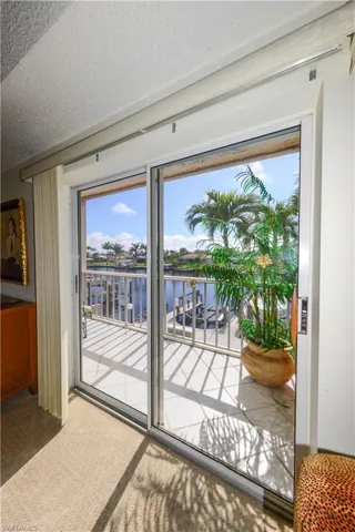 Doorway to outside with a water view, carpet flooring, and a textured ceiling