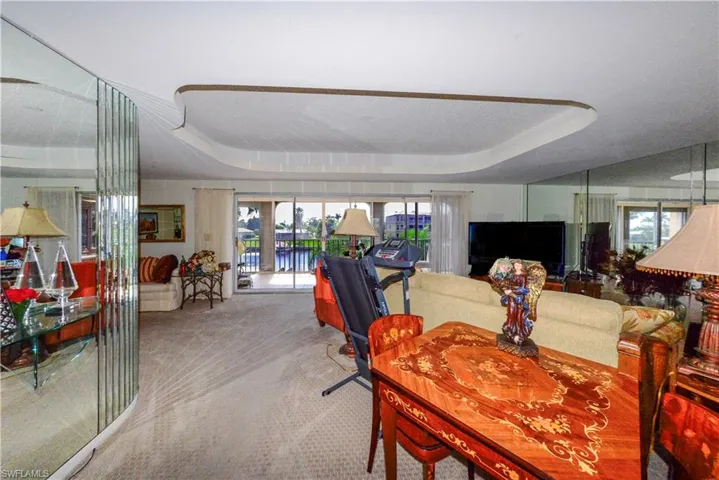 Carpeted dining space featuring a raised ceiling