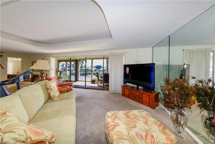 Carpeted living room with a tray ceiling