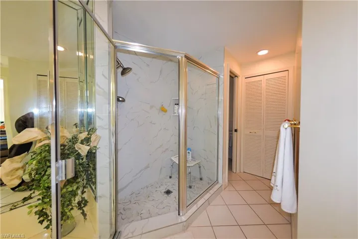 Bathroom with an enclosed shower and tile patterned flooring