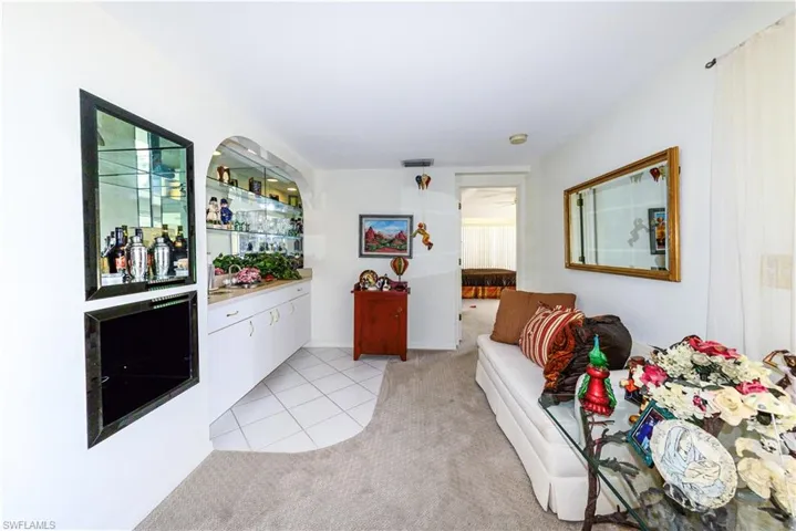 Bar with light colored carpet and white cabinets