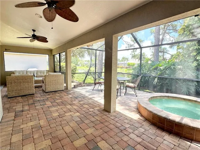 Sunroom with a jacuzzi and ceiling fan
