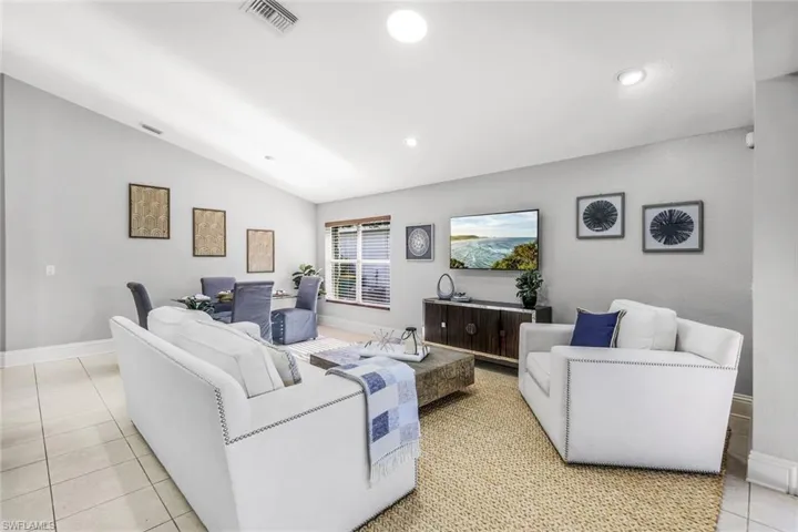 Living room with vaulted ceiling and light tile patterned floors
