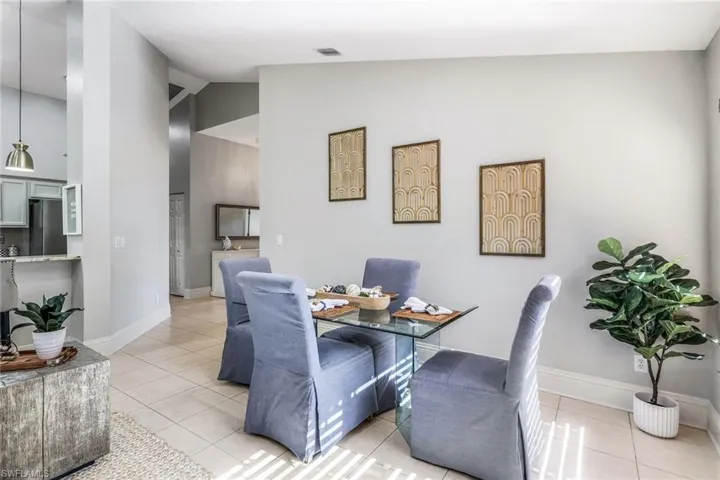 Tiled dining area featuring high vaulted ceiling