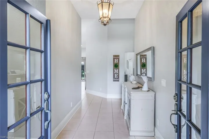 Tiled foyer featuring a notable chandelier