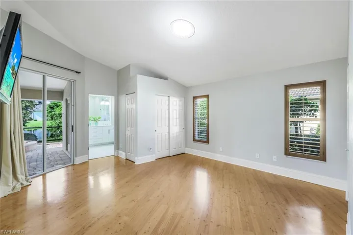 Unfurnished room with light hardwood / wood-style floors, a wealth of natural light, and lofted ceiling