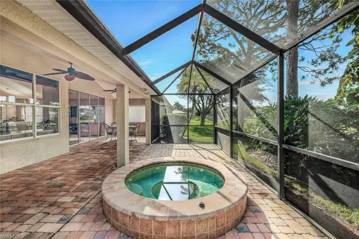 View of swimming pool with a patio, ceiling fan, and glass enclosure