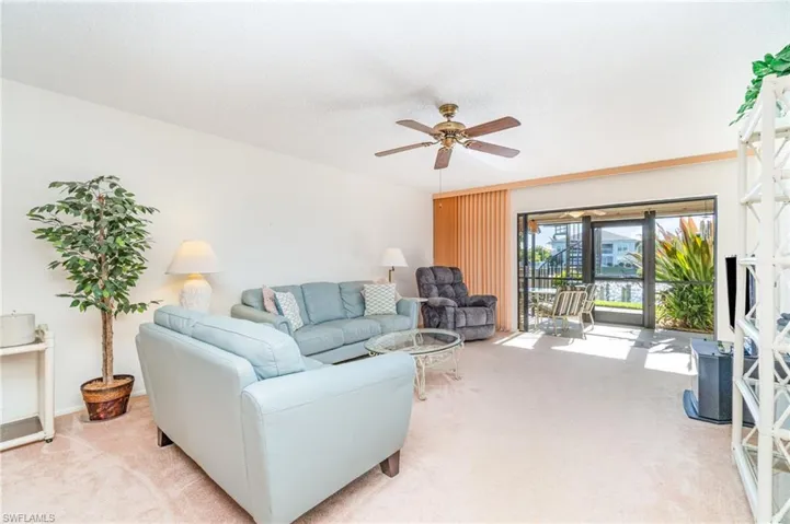 Living room featuring carpet flooring & water view.