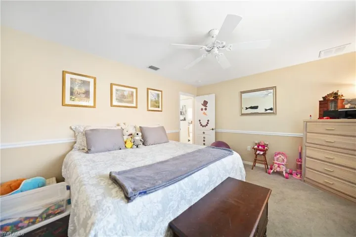 Bedroom with ceiling fan and light carpet