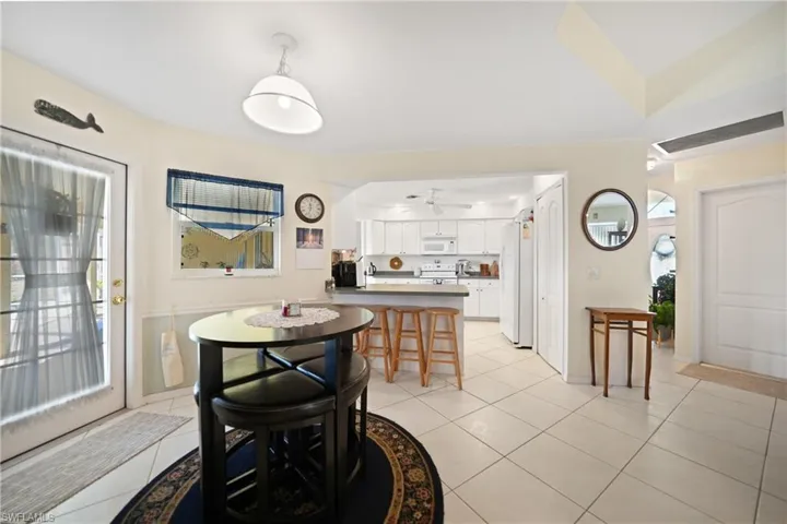 Dining area featuring ceiling fan, a wealth of natural light, and light tile patterned floors
