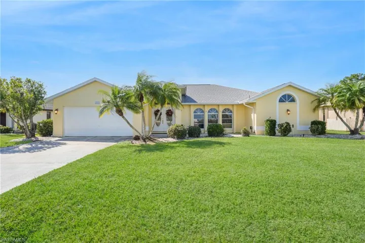Single story home featuring a garage and a front yard