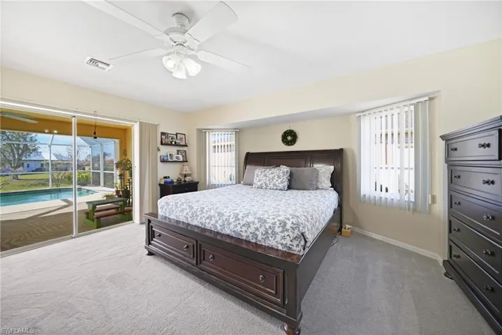 Carpeted bedroom with access to exterior and ceiling fan