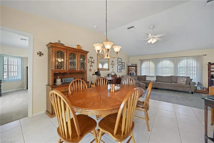 Dining area with plenty of natural light, vaulted ceiling, and light tile patterned floors