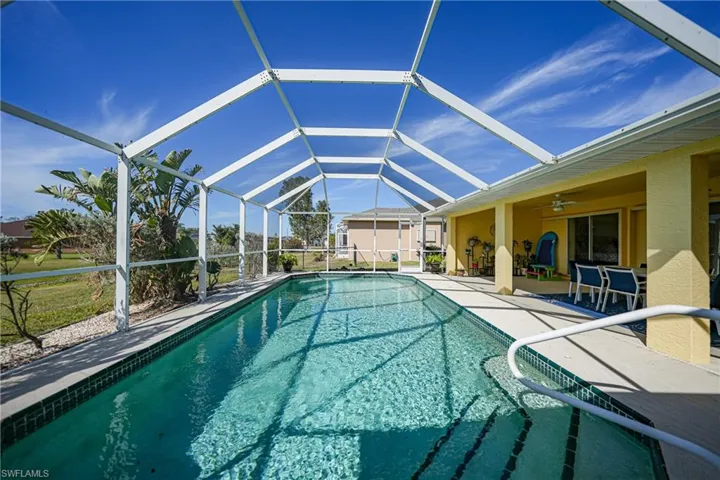 View of swimming pool featuring ceiling fan, a lanai, and a patio area