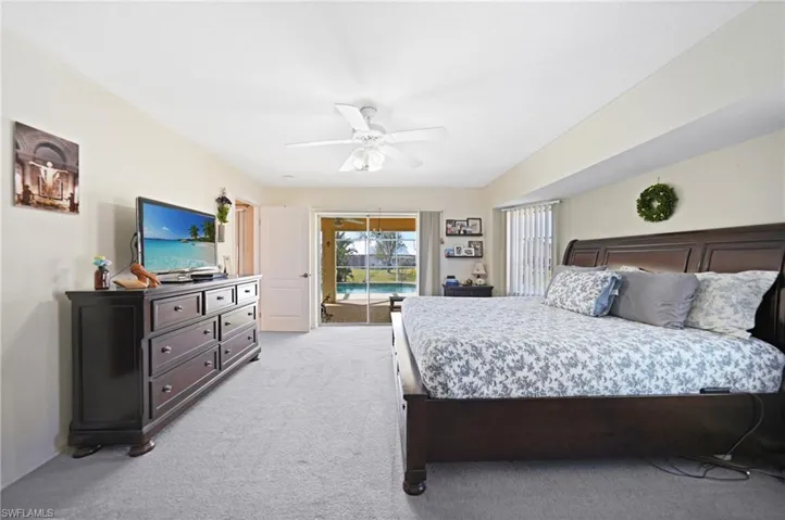 Bedroom with ceiling fan, access to exterior, and light colored carpet