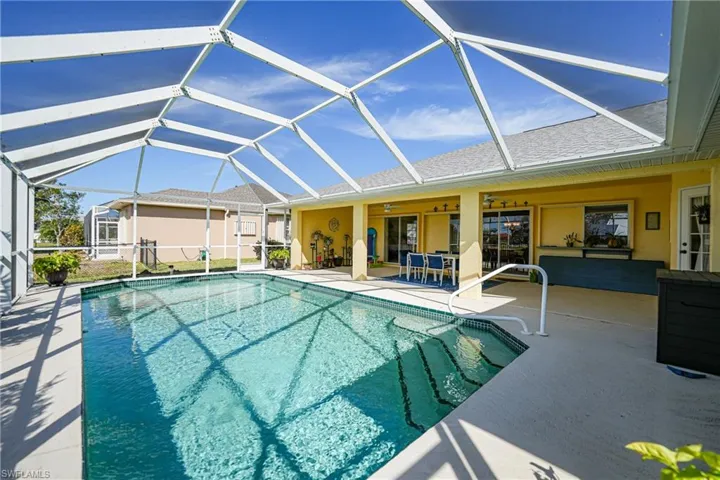 View of pool featuring ceiling fan, a lanai, and a patio area