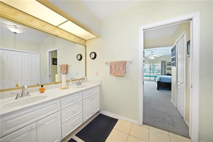 Bathroom featuring ceiling fan, vanity, and tile patterned flooring