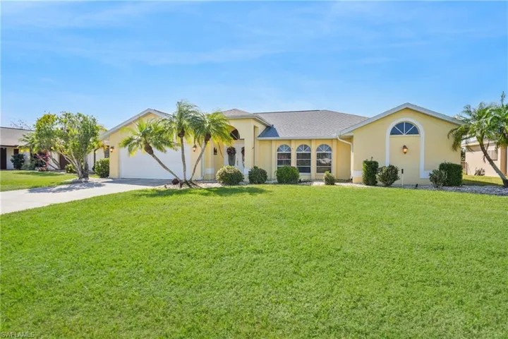 View of front of home with a garage and a front lawn