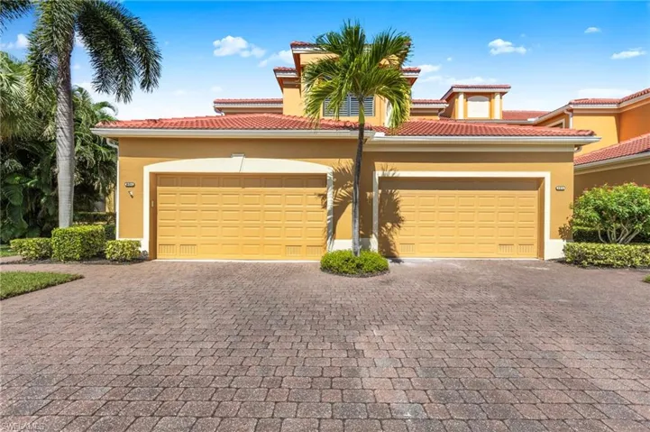 View of front of property with stucco siding, decorative driveway, and a tile roof