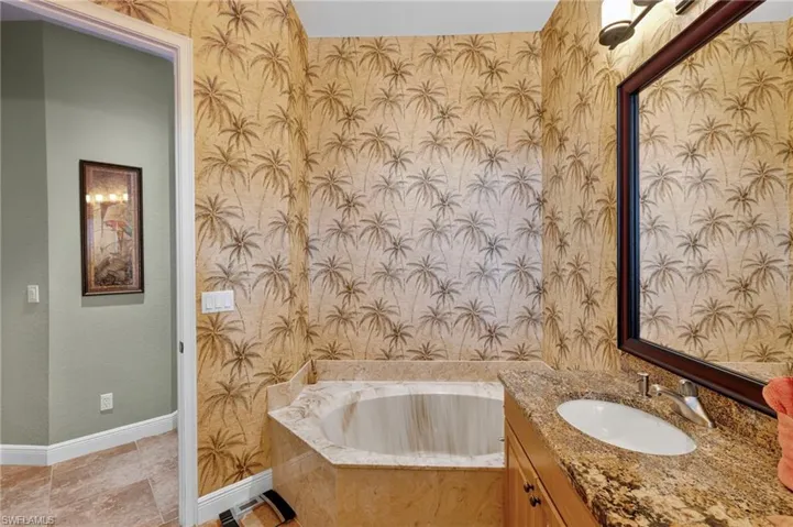 Full bathroom featuring wallpapered walls, a bath, and vanity