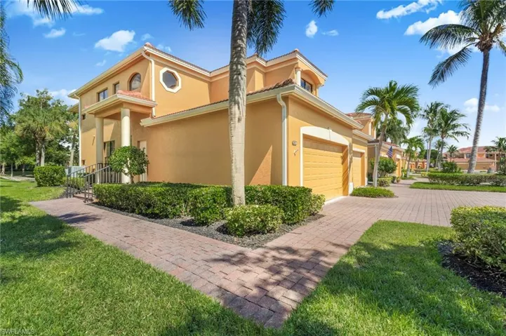 View of side of home featuring a yard, stucco siding, decorative driveway, and an attached garage