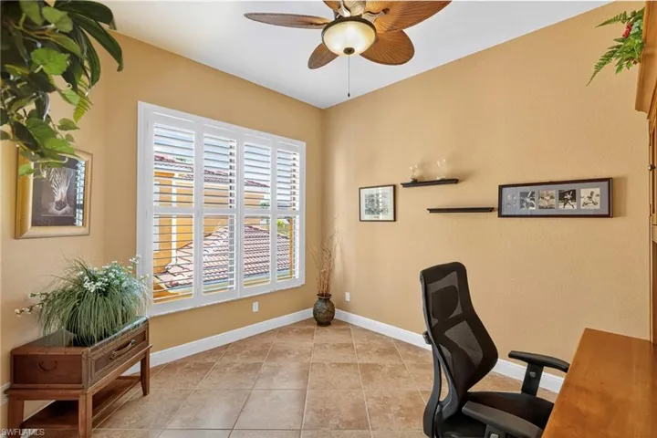 Office area featuring light tile patterned floors and ceiling fan