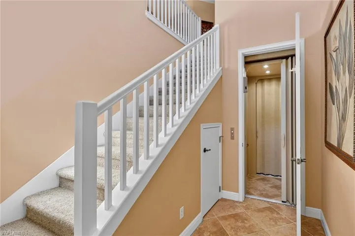 Stairway featuring tile patterned flooring and baseboards