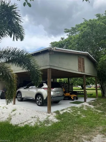 View of car parking with a carport and a lawn